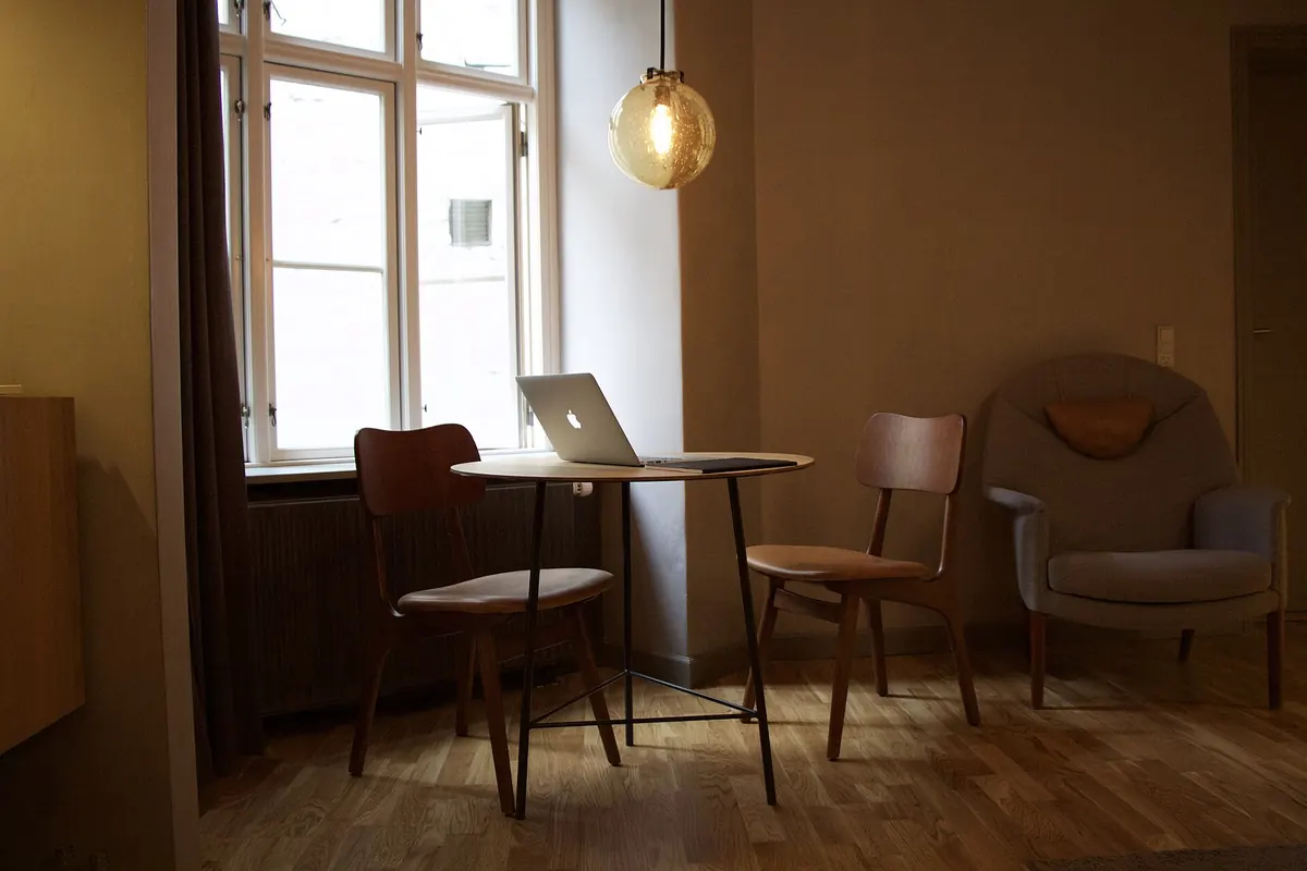 Tidy dining nook with a laptop on a small table after decluttering the home