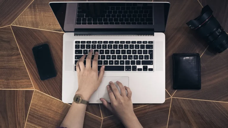 Hands typing on a laptop keyboard, illustrating remote team productivity habits